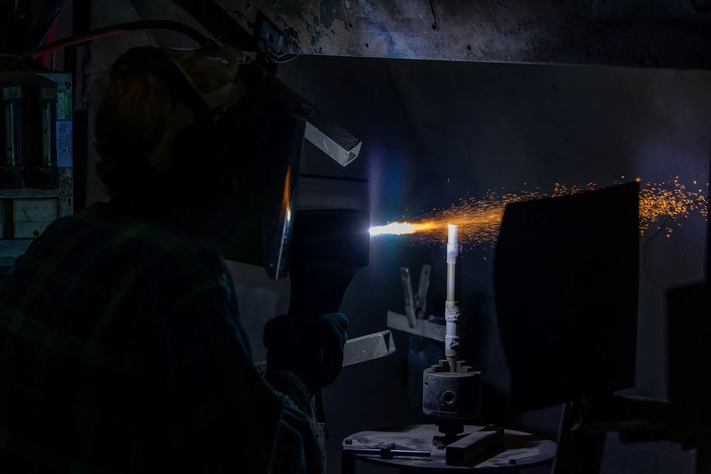 Operator hand-spraying a component in the job shop