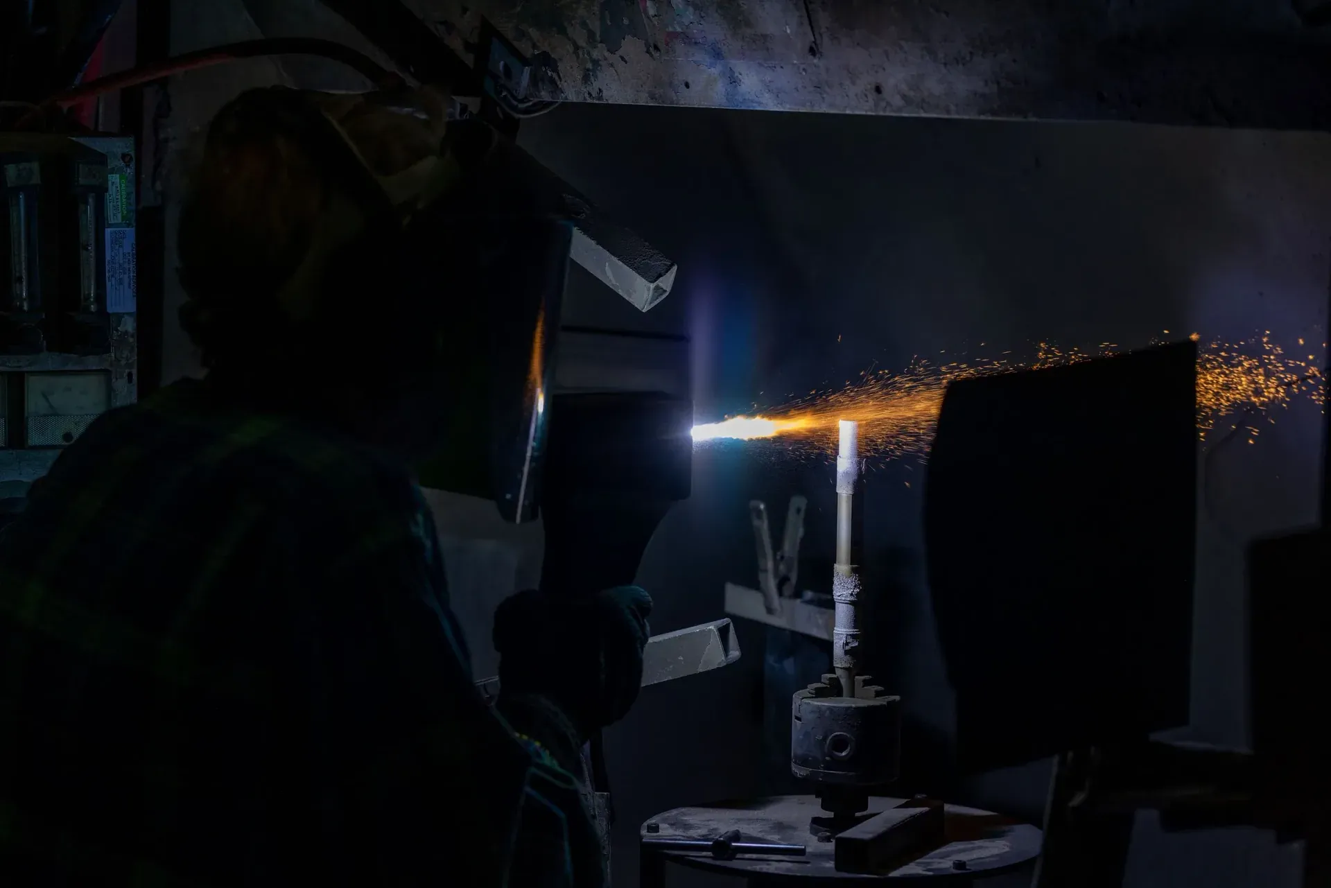 Operator hand-spraying a component in the job shop