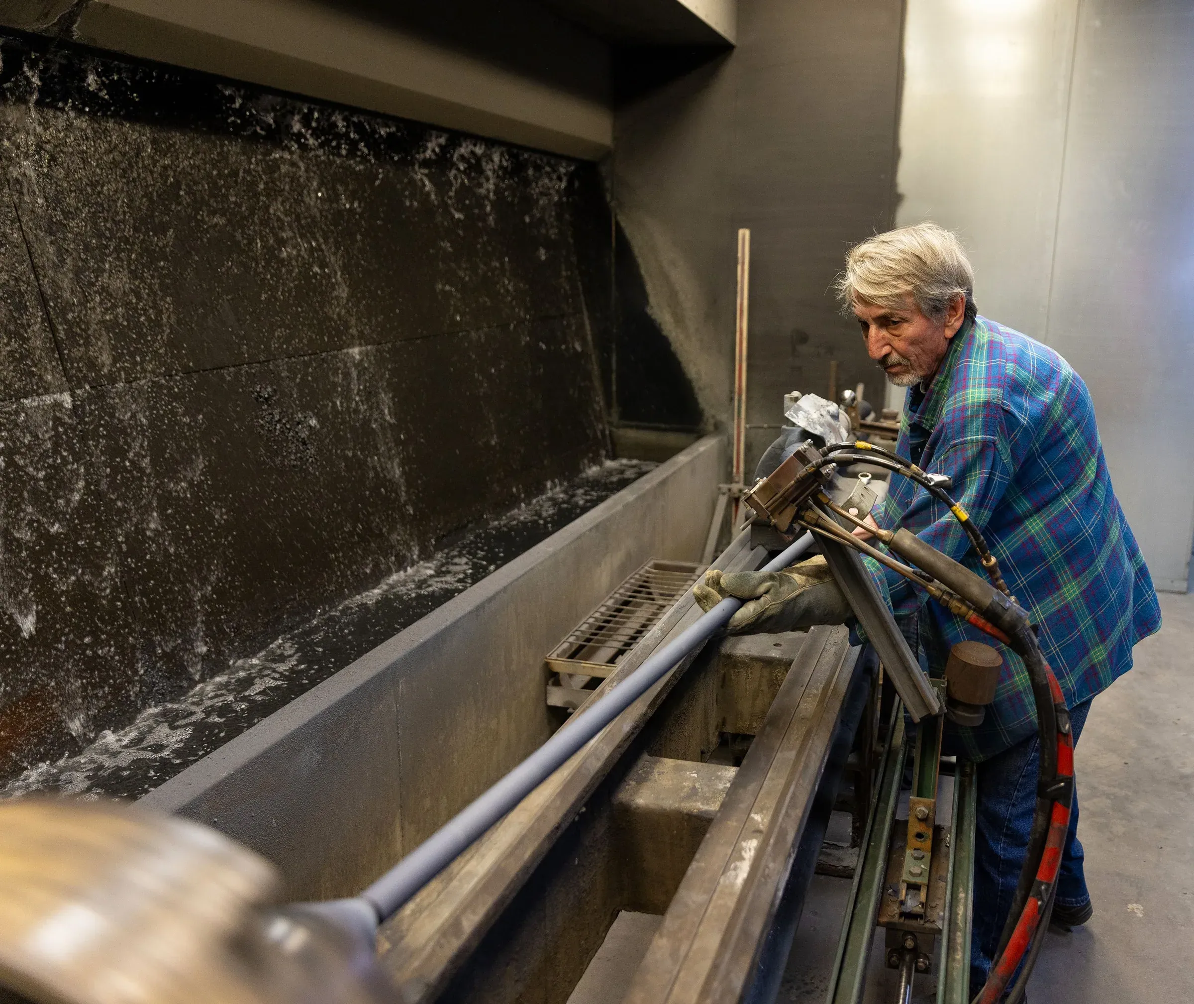 Operator setting up a long component in the jobshop spray booth