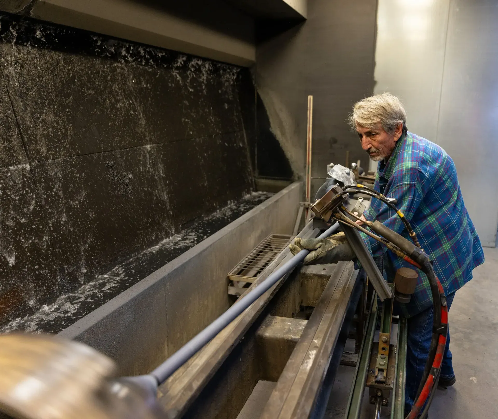 Operator setting up a long component in the jobshop spray booth