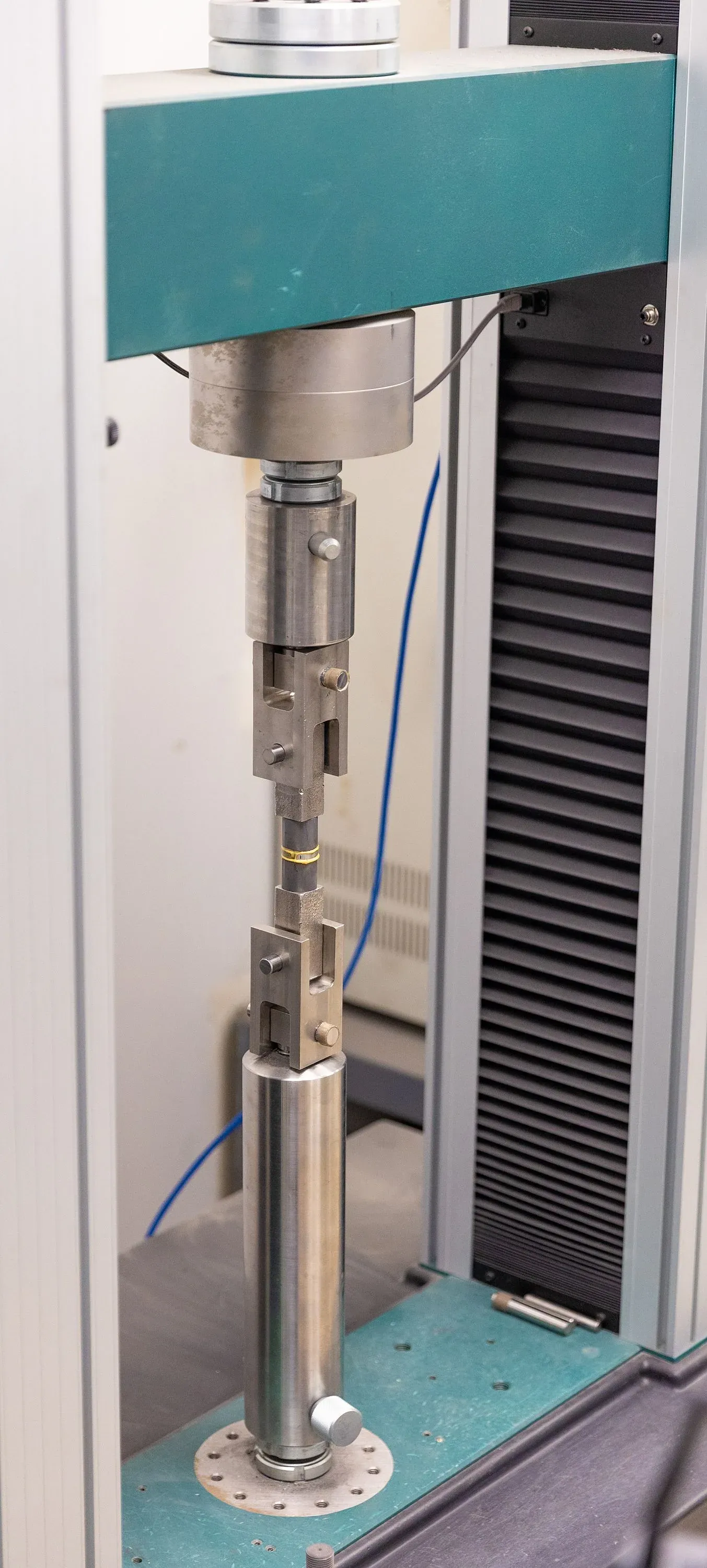 Tensile adhesion test fixture in a universal testing machine