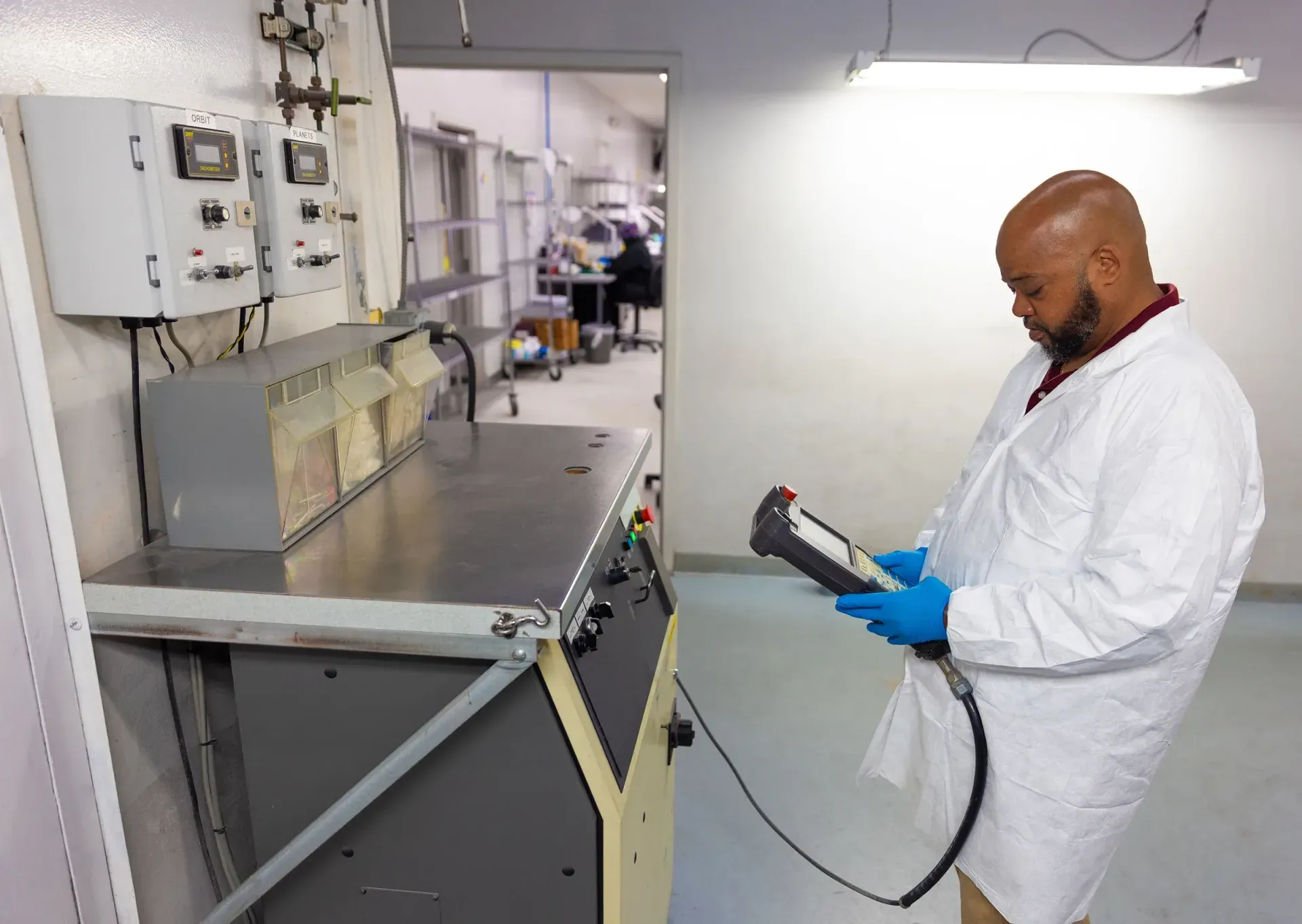 Technician programming a robotic thermal spray cell