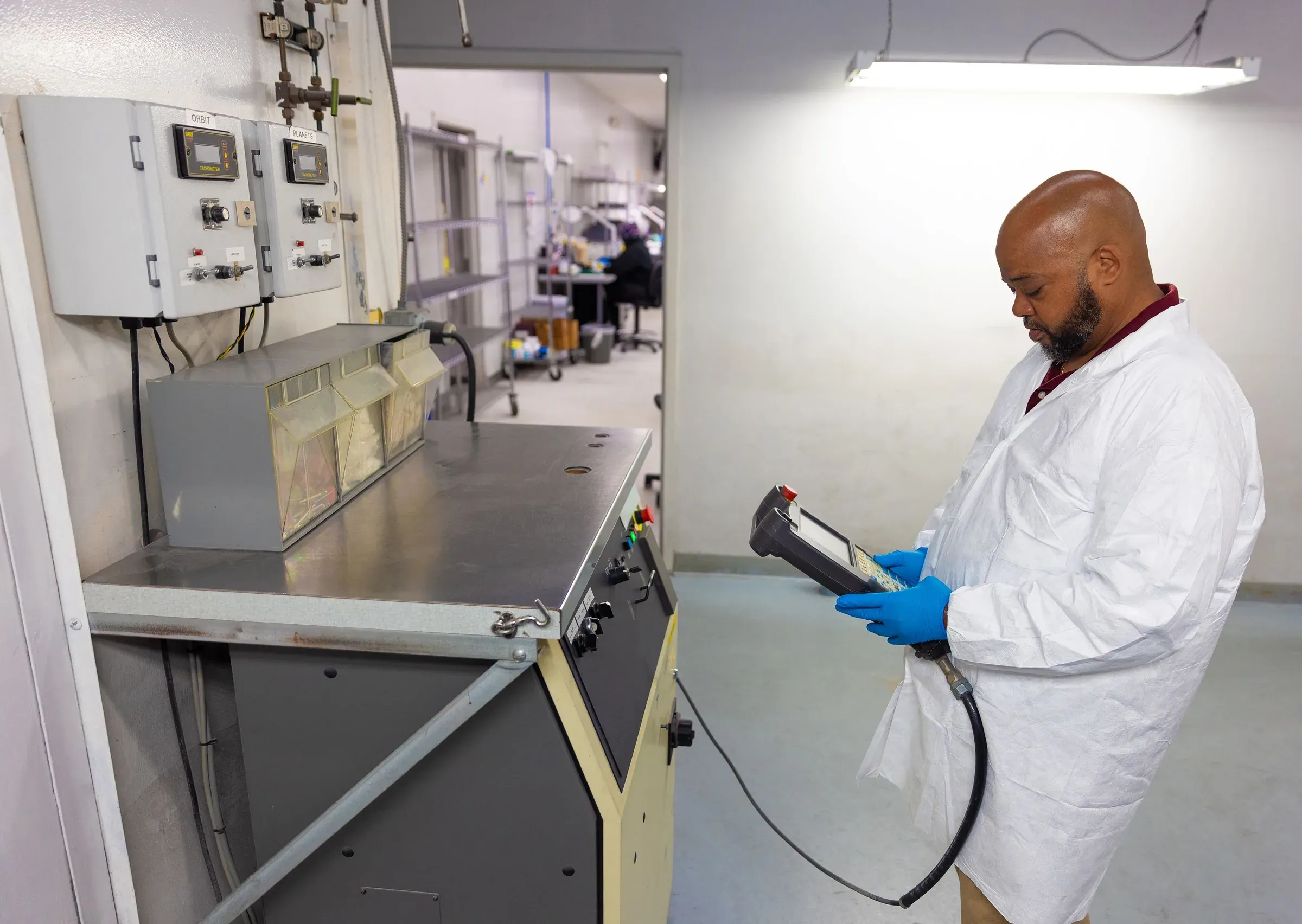 Technician programming a robotic thermal spray cell