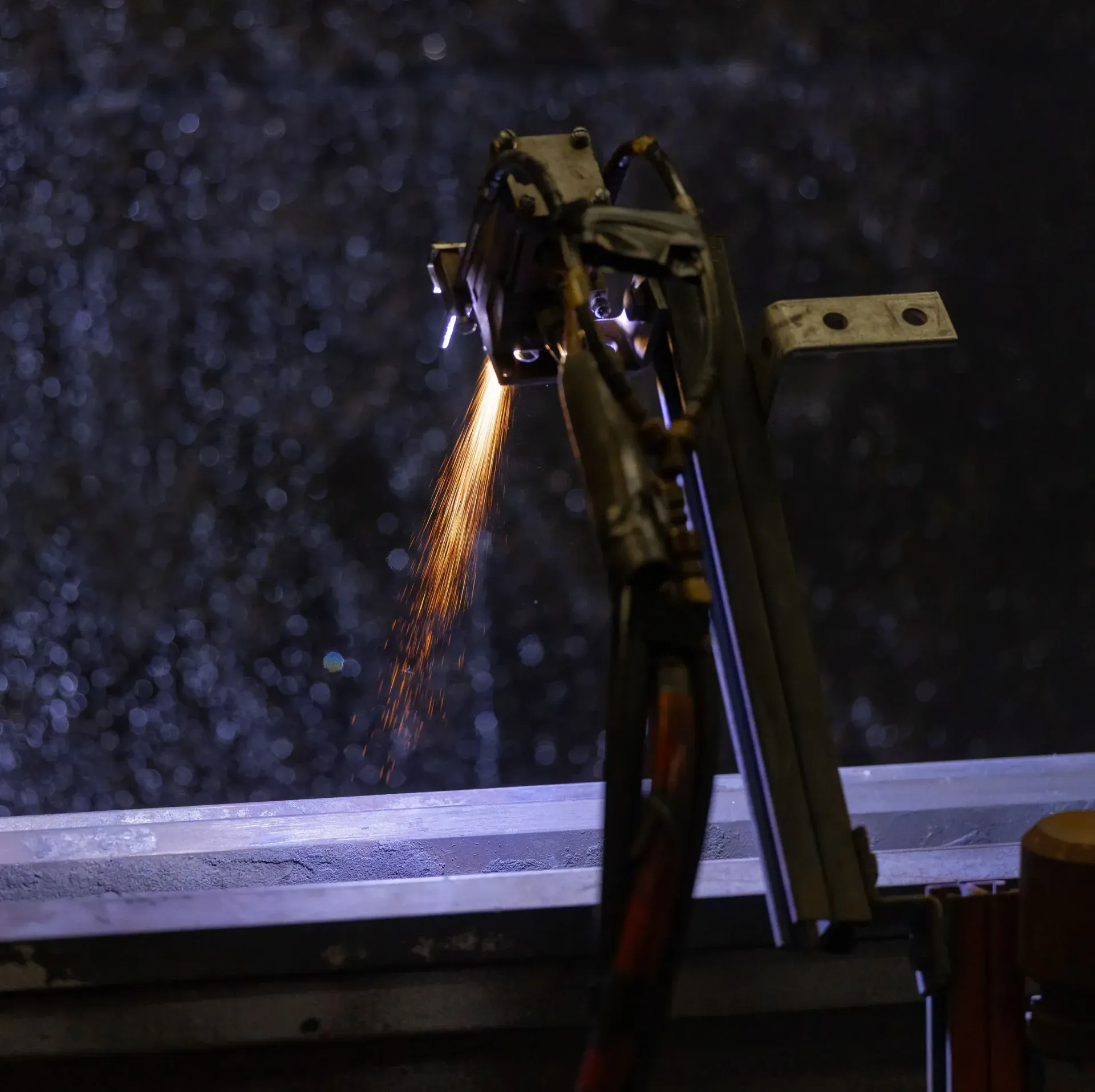 Thermal spray plume against a dark spray booth interior